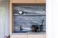 Moderne Küchenecke mit Marmorwand, Kaffeemaschine und Spüle