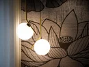 Moderne Hängeleuchten vor einer Wand mit großem Blumenmuster