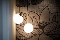 Moderne Hängeleuchten vor einer Wand mit großem Blumenmuster