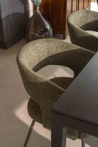 Gepolsterter Esszimmerstuhl neben einem Tisch und einer Dekovase