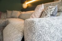 Nahaufnahme eines grauen Sofas mit gemusterten Kissen