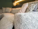 Nahaufnahme eines grauen Sofas mit gemusterten Kissen