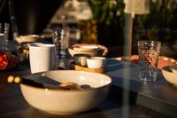 Tisch mit Keramikgeschirr und Gläsern im Sonnenlicht