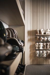 Regal mit Kinderspielzeugen und Autositzen in einem Raum mit Holzverkleidung