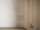 Parete attrezzata in legno minimalista con mensola rotonda in cemento e maniglia nera