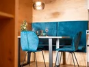 Moderner Essbereich mit blauen Stühlen und Bank vor Holzpaneelen