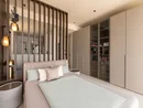 INTERIOS. Il tuo studio di interior design. Camera da letto moderna con letto matrimoniale, parete a doghe e armadio a muro