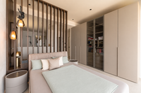 Modernes Schlafzimmer mit Doppelbett, Holzlamellenwand und Einbauschrank
