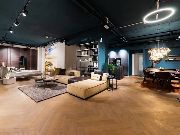 Modernes Wohnzimmer mit beiger Couch, Esstisch und blauen Wänden