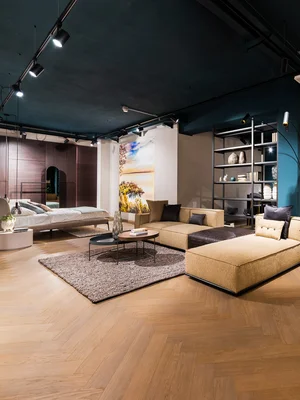 Modernes Wohnzimmer mit beiger Couch, Esstisch und blauen Wänden