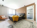 Modernes Schlafzimmer mit grauem Bett, gelber Decke und angrenzendem Bad