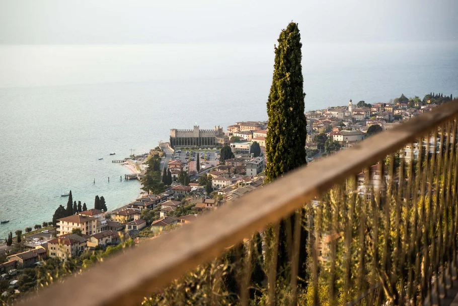 Blick auf den Gardasee und das Städtchen mit hoher Zypresse im Vordergrund