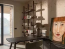 INTERIOS. Il tuo studio di interior design. Studio moderno con scrivania, libreria e quadro raffigurante un ritratto