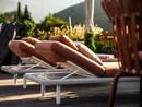 Bequeme Liegestühle mit braunen Kissen auf Terrasse im Sonnenlicht