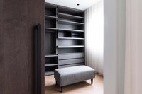 Moderner begehbarer Kleiderschrank mit grauen Regalen und gepolsterter Bank