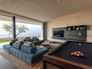 Modernes Wohnzimmer mit Billardtisch und Panoramafenster mit Seeblick