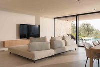 Modernes Wohnzimmer mit Sofas, Fernseher und Blick auf Pool und Garten