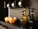 Dekorative Glasflaschen und Holzschalen auf dunklem Regal