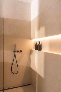 Modernes Badezimmer mit schwarzer Regendusche und zwei Seifenspendern