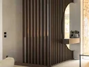INTERIOS. Il tuo studio di interior design. Soggiorno moderno con parete a doghe in legno scuro, apertura ad arco e divano chiaro
