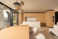 Offener Wohn- und Essbereich mit Holztisch, Kücheninsel, Hängeleuchten und weißem Sofa