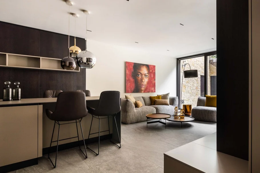 Modernes Wohnzimmer mit Stühlen, Teppich, Kunst an der Wand und großen Fenstern