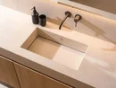 INTERIOS. Il tuo studio di interior design. Lavabo moderno con dispenser di sapone nero e bicchiere su piano chiaro