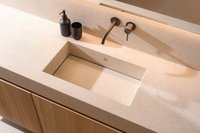 Modernes Waschbecken mit schwarzem Seifenspender und Becher auf hellem Waschtisch