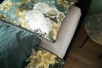 Nahaufnahme von Kissen mit Blumenmuster auf Bett neben rundem Tisch