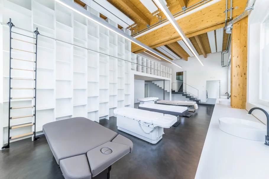 Moderner Behandlungsraum mit Therapieliegen und Holzdecke