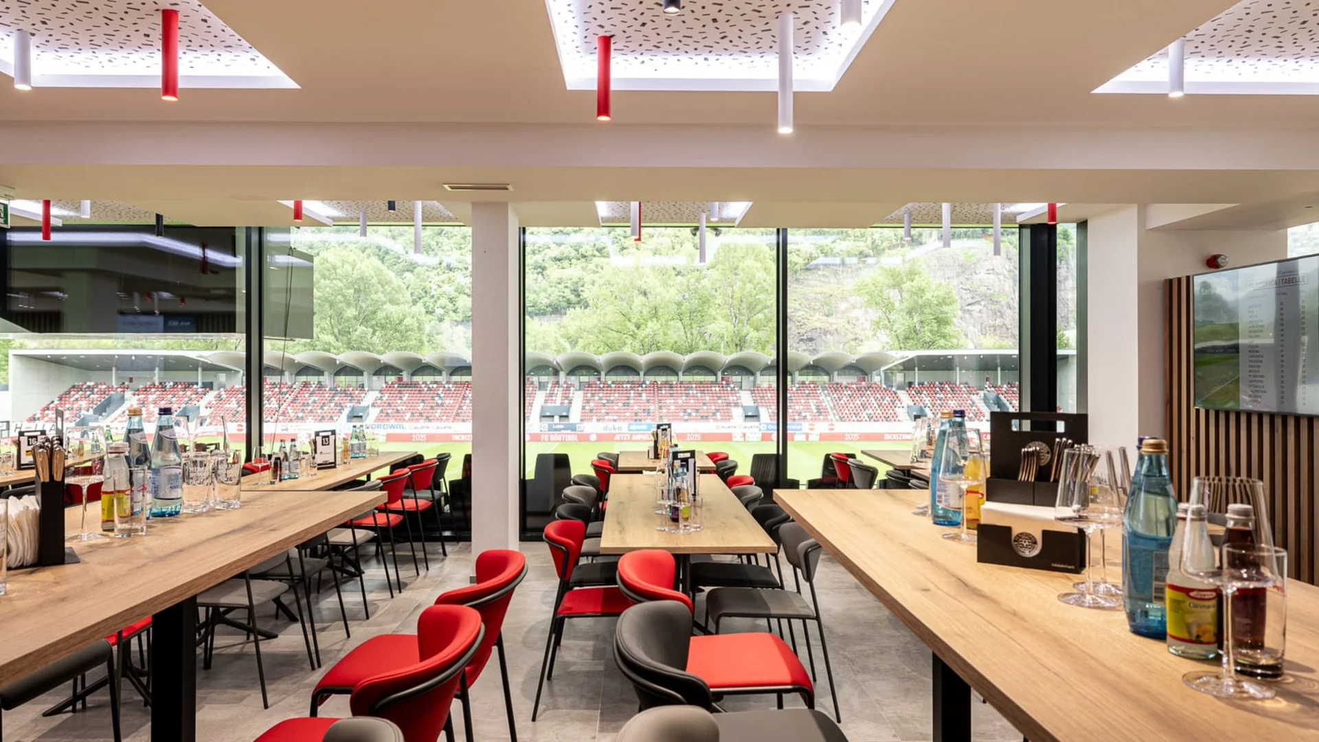 Innenansicht eines modernen Restaurants mit Blick auf ein Fußballstadion