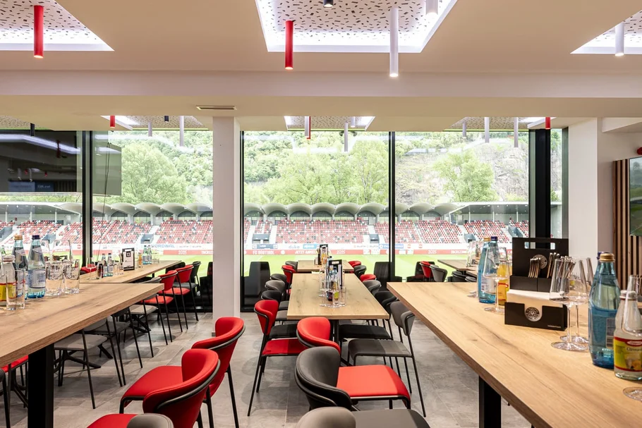 Innenansicht eines modernen Restaurants mit Blick auf ein Fußballstadion