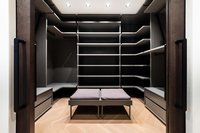 Leerer begehbarer Kleiderschrank mit grauen Regalen und Sitzbank
