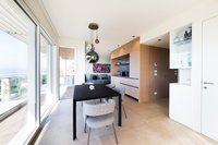 Moderner Essbereich mit schwarz Tisch, grauen Stühlen und großem Fenster zur Terrasse